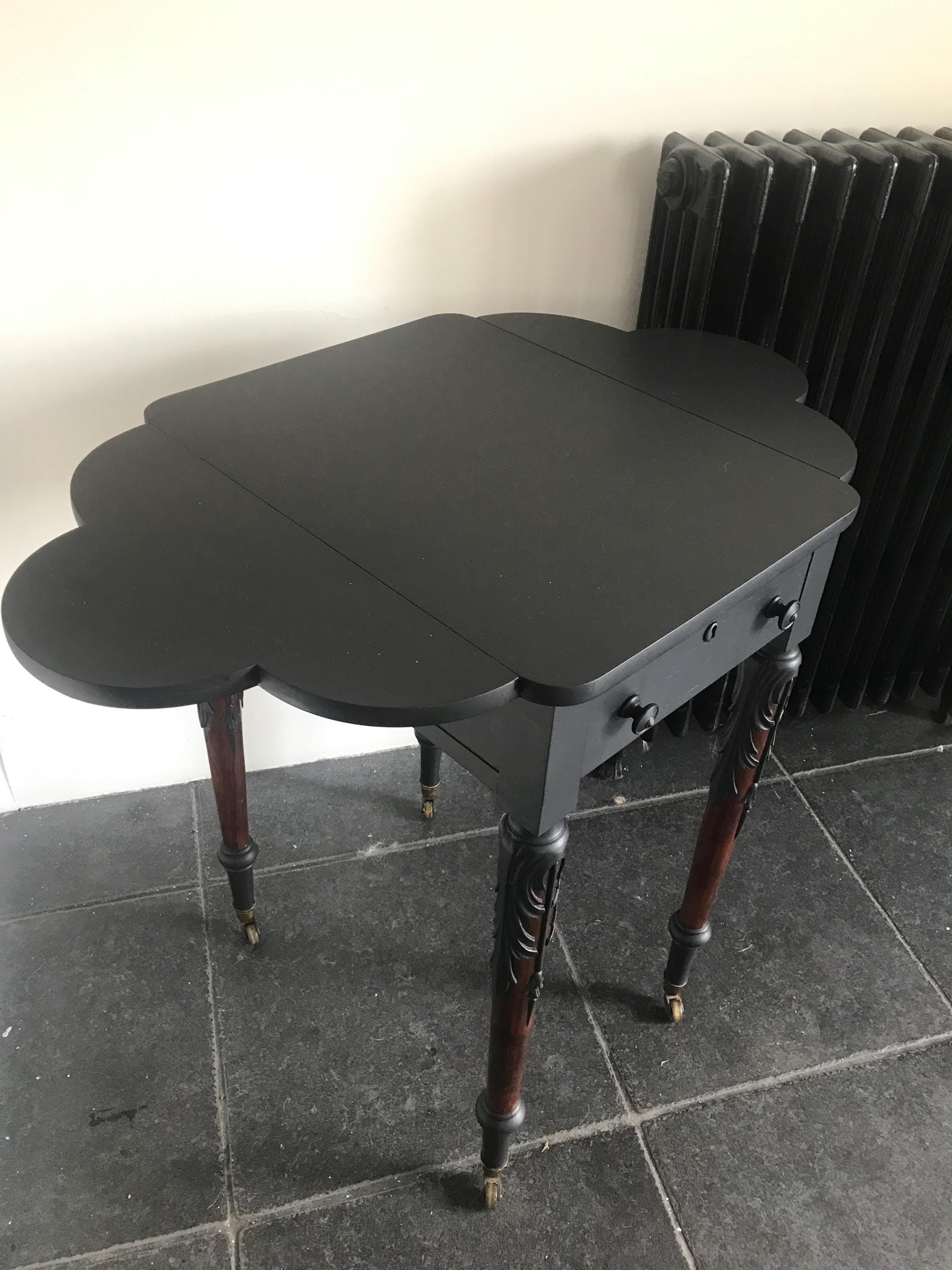 Elegant Antique  Black  Ornate Carved Table with antique casters.